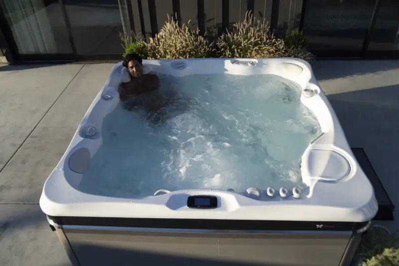 Person relaxing in a hot tub at night
