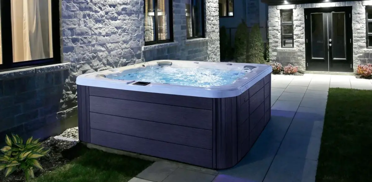 Hot tub on a stone patio beside a modern house