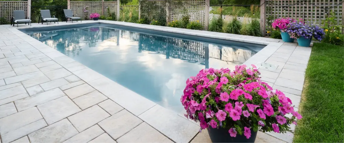 Rectangular pool with pink flowers on the stone deck