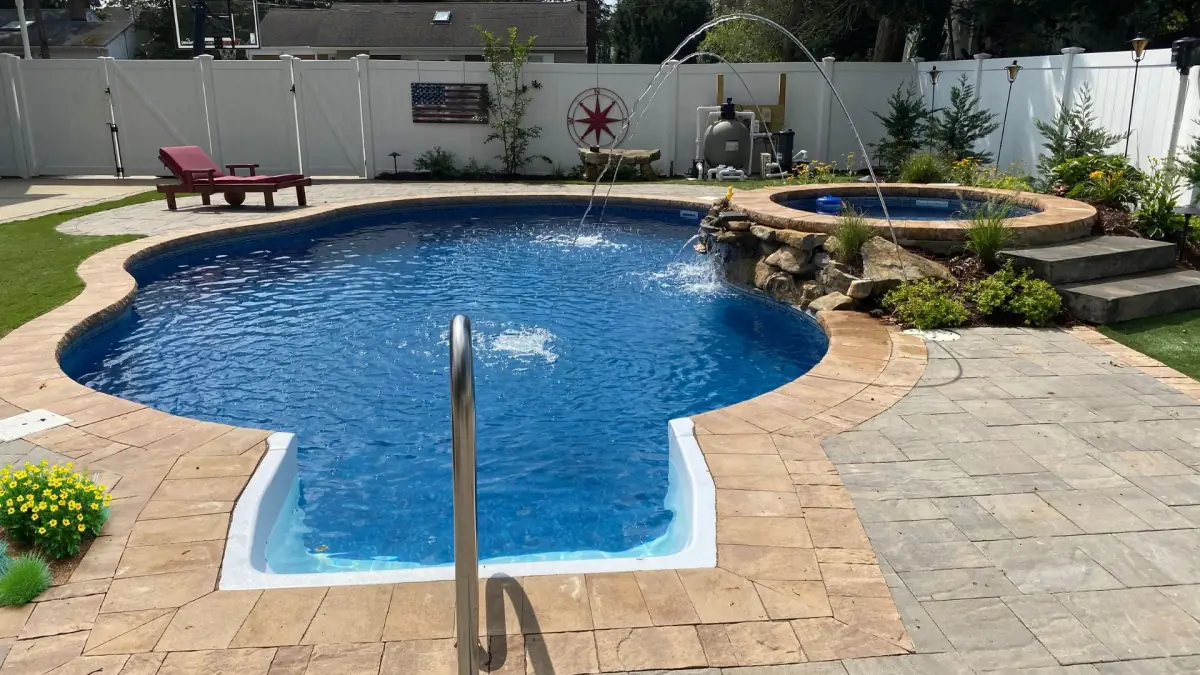 Inground vinyl pool with a fountain and paver patio