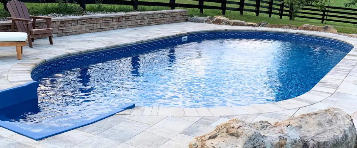Blue inground pool with a stone coping